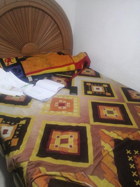 a bed with a colorful quilt on top of it at Hotel in Celaya