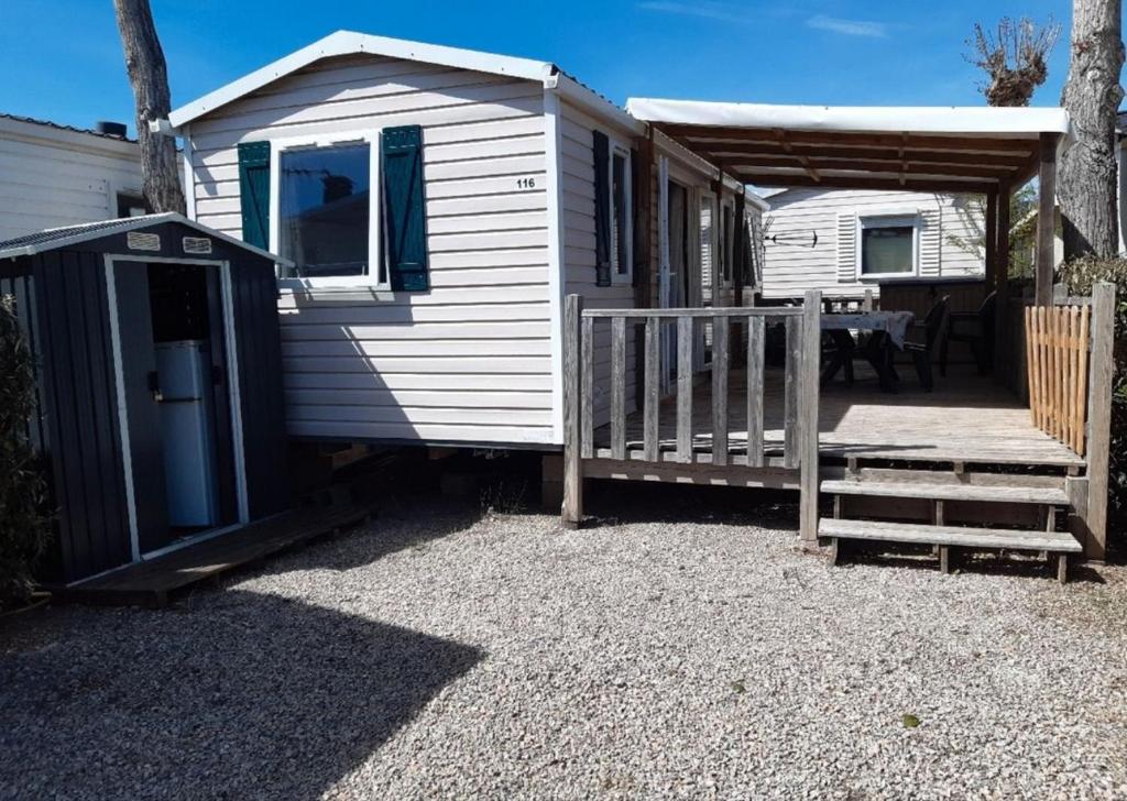 un mobil-home avec un porche et une rampe en bois dans l'établissement Europcamping Mobil-home Climatisé, à Fréjus