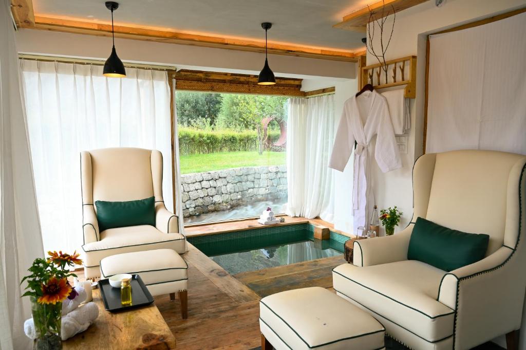 two chairs and a table in a living room at Stone Hedge Hotel in Nubra