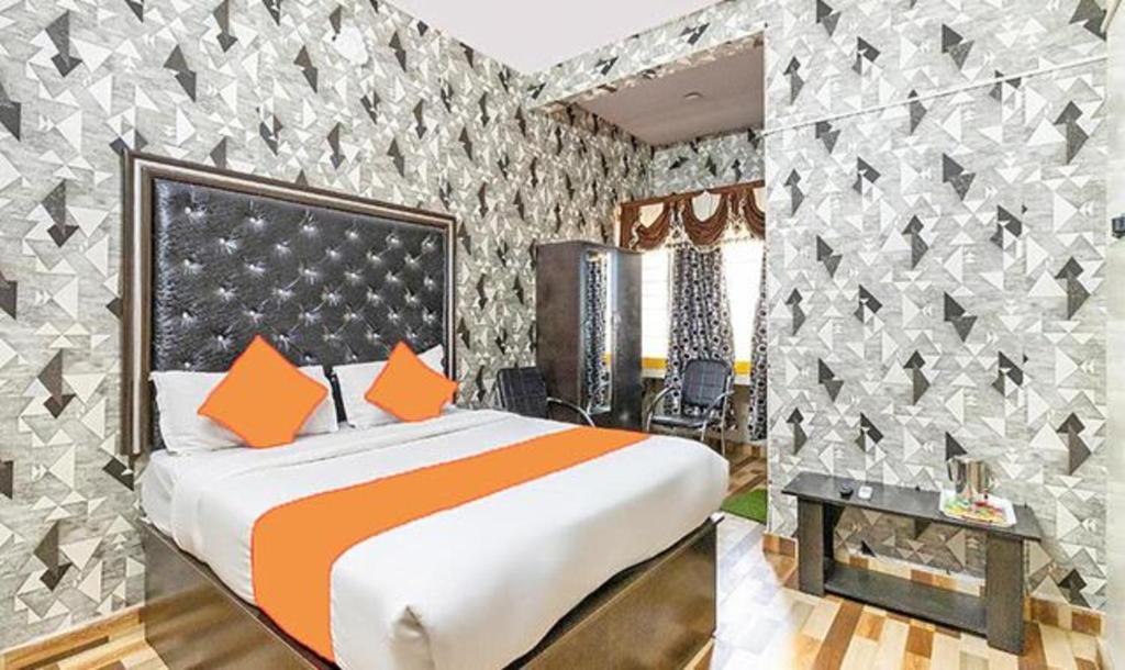ein Schlafzimmer mit einem großen Bett und einer Wand mit Mustern in der Unterkunft FabExpress Pavithraa Edition in Bangalore
