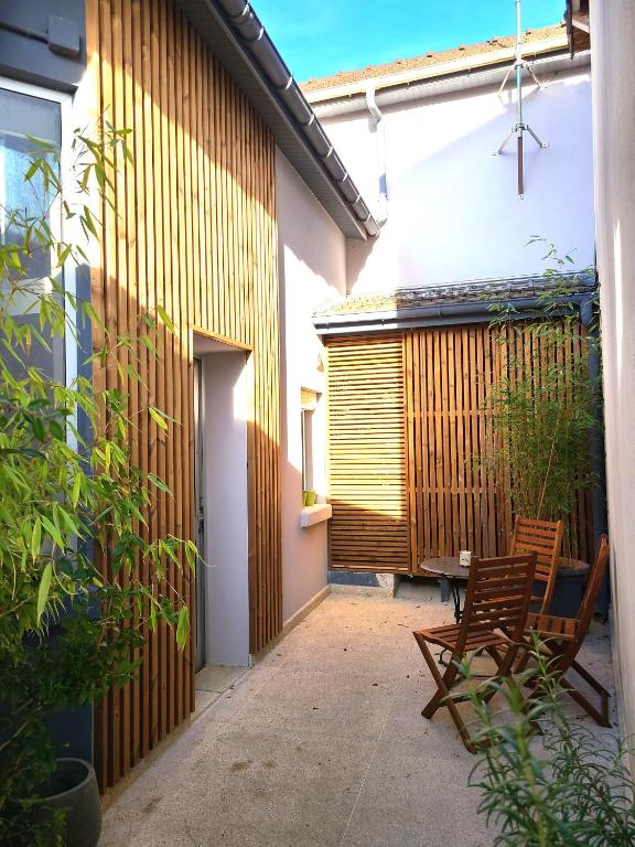 un patio avec deux chaises et une table à côté d'un bâtiment dans l'établissement Appartement Duplex 40 M², à Fontenay-Trésigny