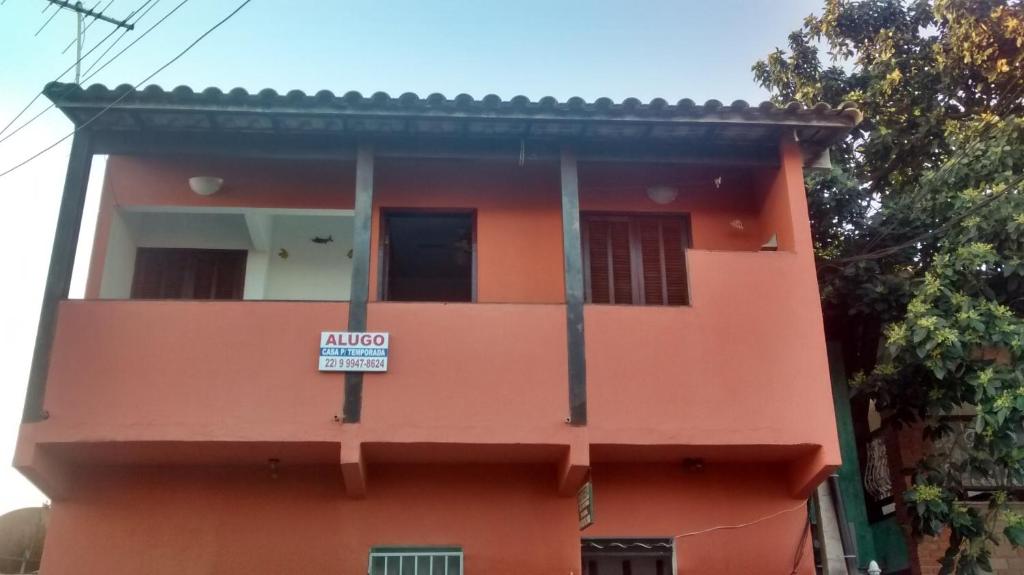 un edificio naranja con un letrero. en Casa Temporada Centro De Búzios, en Búzios