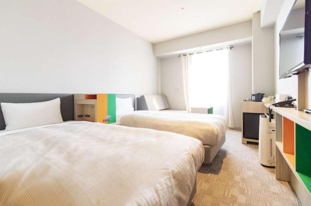 Postel nebo postele na pokoji v ubytování HOTEL FUKURACIA OSAKA-BAY