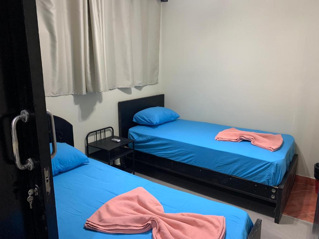 - 2 lits dans une petite chambre avec des draps bleus dans l'établissement PORTO MARINA North Coast -الساحل الشمالي بورتو مارينا العلمين, à El Alamein