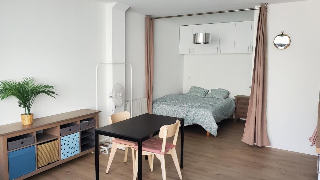 une chambre avec une table, des chaises et un lit dans l'établissement Studio indépendant de 30 m² - St Cléophas, à Montpellier