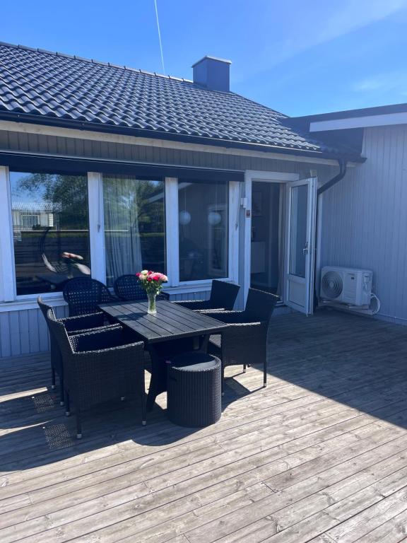 a patio with a table and chairs on a deck at Villa, Barnvänlig, nära strand/shopping in Halmstad