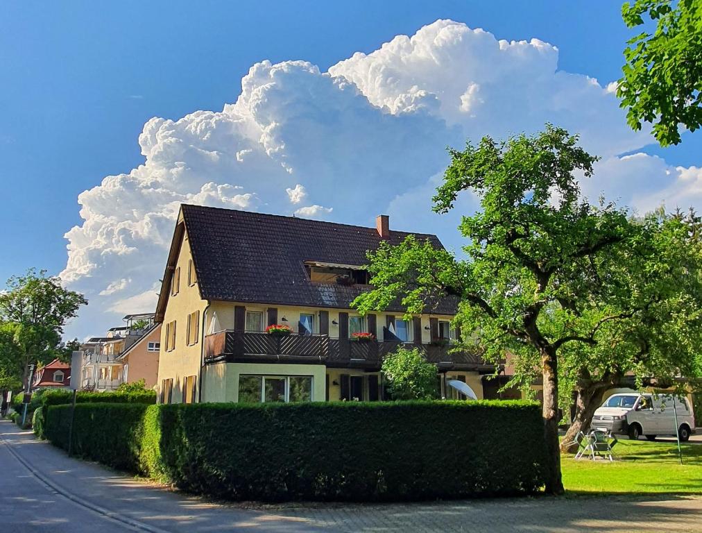 ein Haus an der Seite einer Straße mit einem Baum in der Unterkunft Gästehaus Mäder in Bad Dürrheim