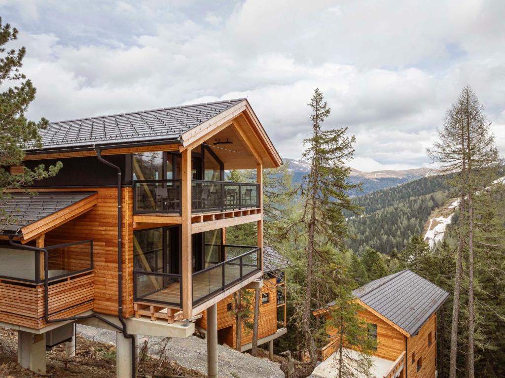 a cabin in the woods with a view of the mountains at Naturchalets Turracher Höhe by ALPS RESORTS in Turracher Hohe