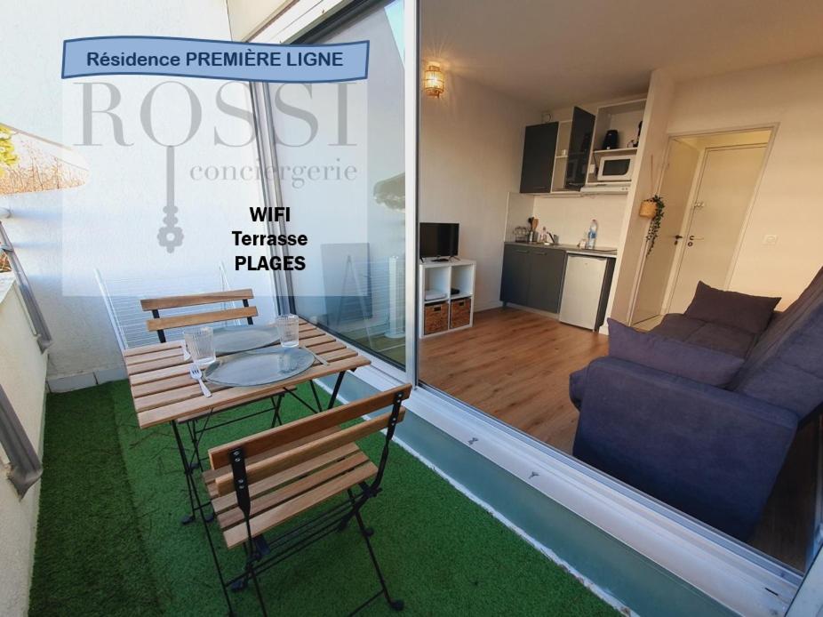 a living room with a table and a couch at Suite Thalassa première ligne Couchant Wifi - ROSSIconciergerie - Linge inclus in La Grande Motte