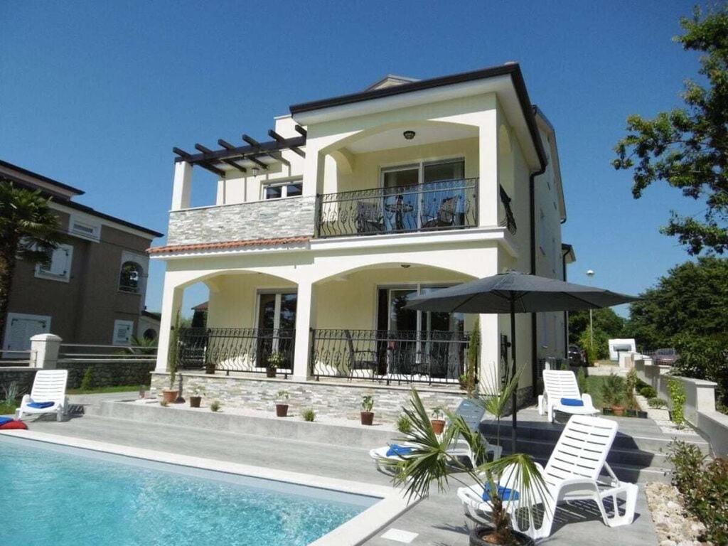 una casa con piscina al lado de un edificio en Villa Luka Apartent Gray, en Funtana