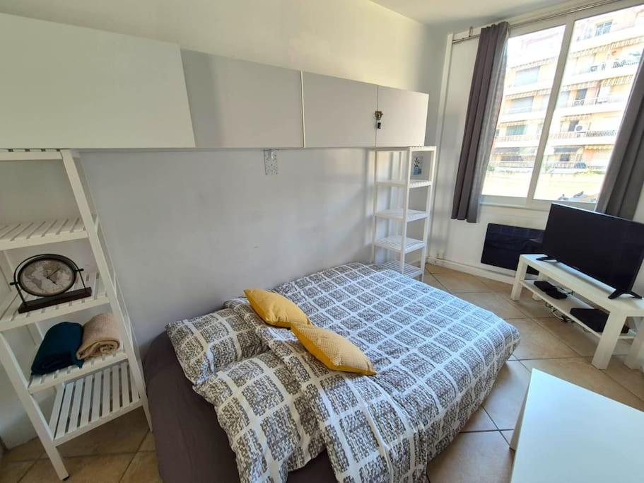 une chambre avec un lit avec des oreillers jaunes dessus dans l'établissement Studio plein centre de Juan - Proche plage et gare, à Antibes