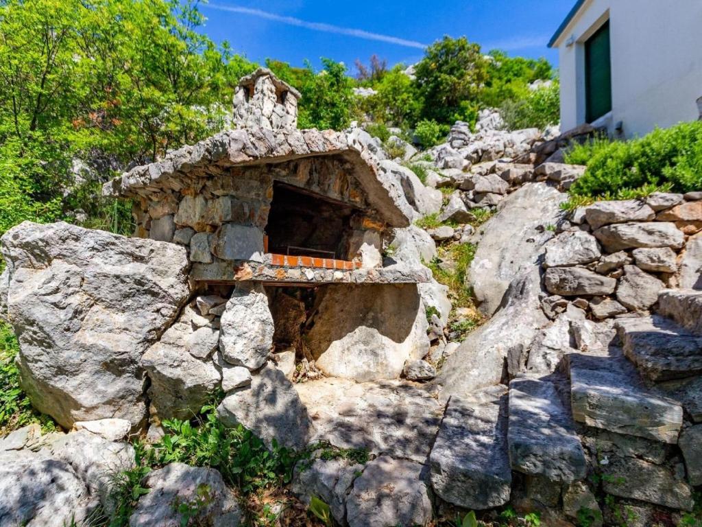 kamienny dom na skalistym wzgórzu z oknem w obiekcie Holiday Home in Starigrad near Paklenica w mieście Starigrad-Paklenica