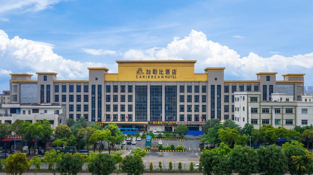 a large building with a sign on top of it at Caribbean Hotel Zhongshan in Zhongshan