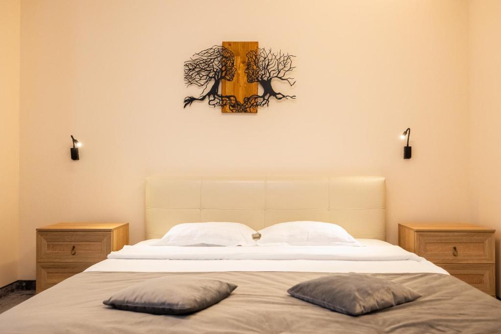 a bedroom with a bed with two pillows on it at Pensiunea Floarea Soarelui in Braşov