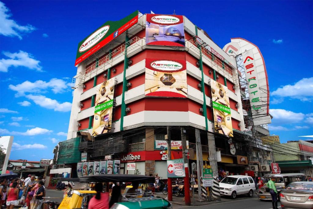 a tall building with a lot of signs on it at Astrotel Calamba in Calamba