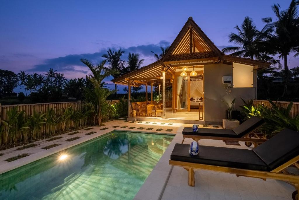 a villa with a swimming pool and a house at Oemah Cinta Ubud Villa in Ubud