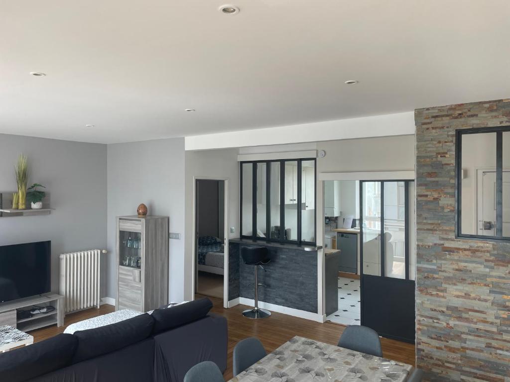 a living room with a blue couch and a brick wall at Jaurès-Pilier rouge/App spacieux/3 chambres/6 pers in Brest