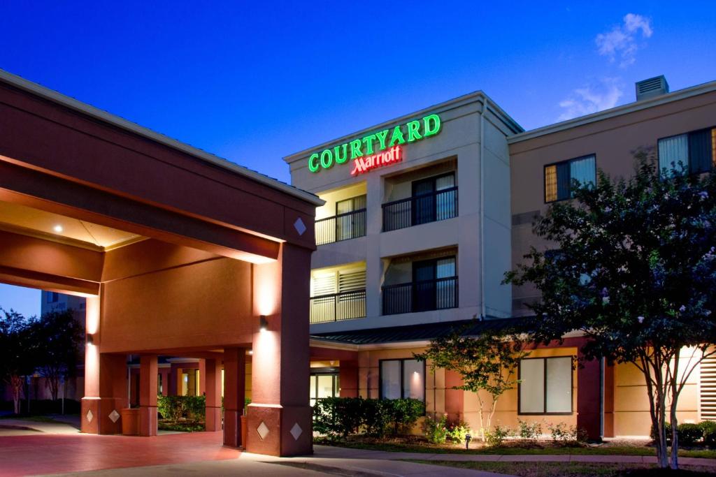 a hotel building with a sign for a courtyard marriott at Courtyard by Marriott Bryan College Station in College Station
