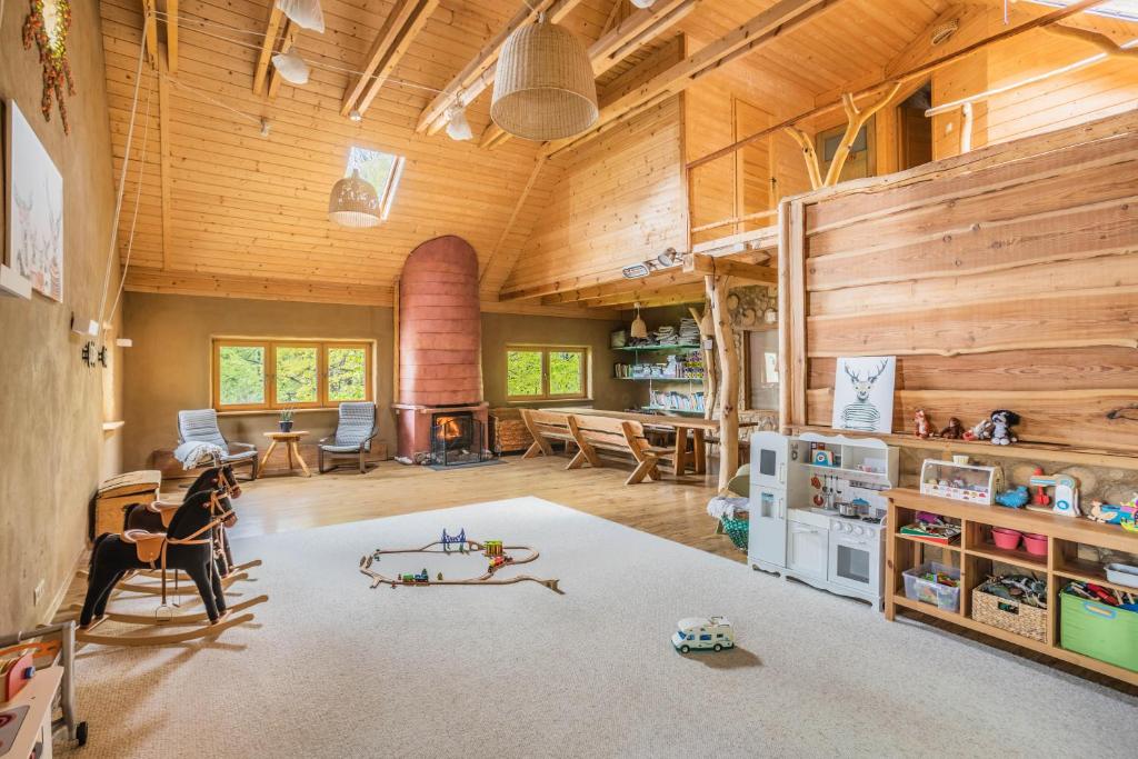 una gran sala de estar con paredes de madera y techo de madera. en Osada Jelonki Wielka Puszcza en Porąbka