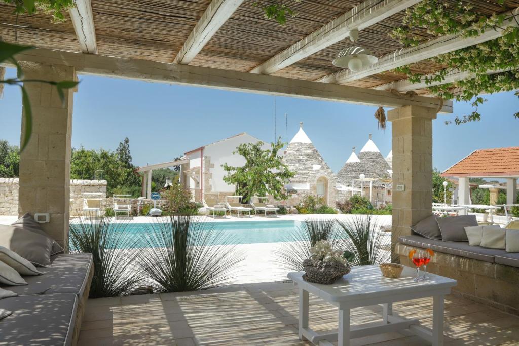 a patio with a view of a swimming pool at Trulli&Dimore - Casette Pricci in Castellana Grotte