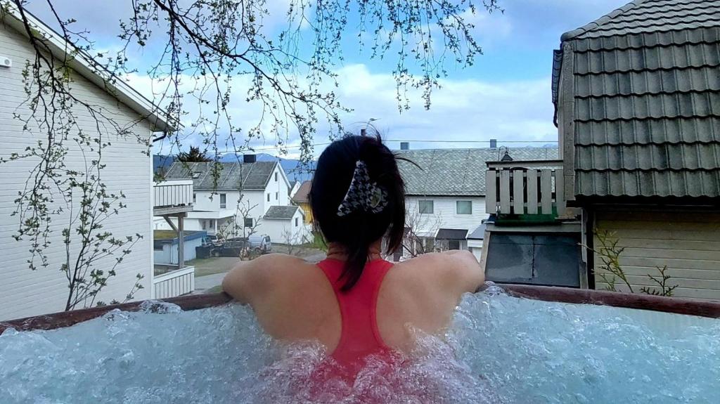 a woman in a hot tub in a backyard at The perfect stop in Lødingen