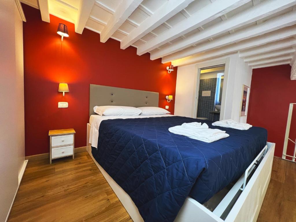 Un dormitorio con una gran cama azul con paredes rojas en LOFT IN FLORENCE en Florence