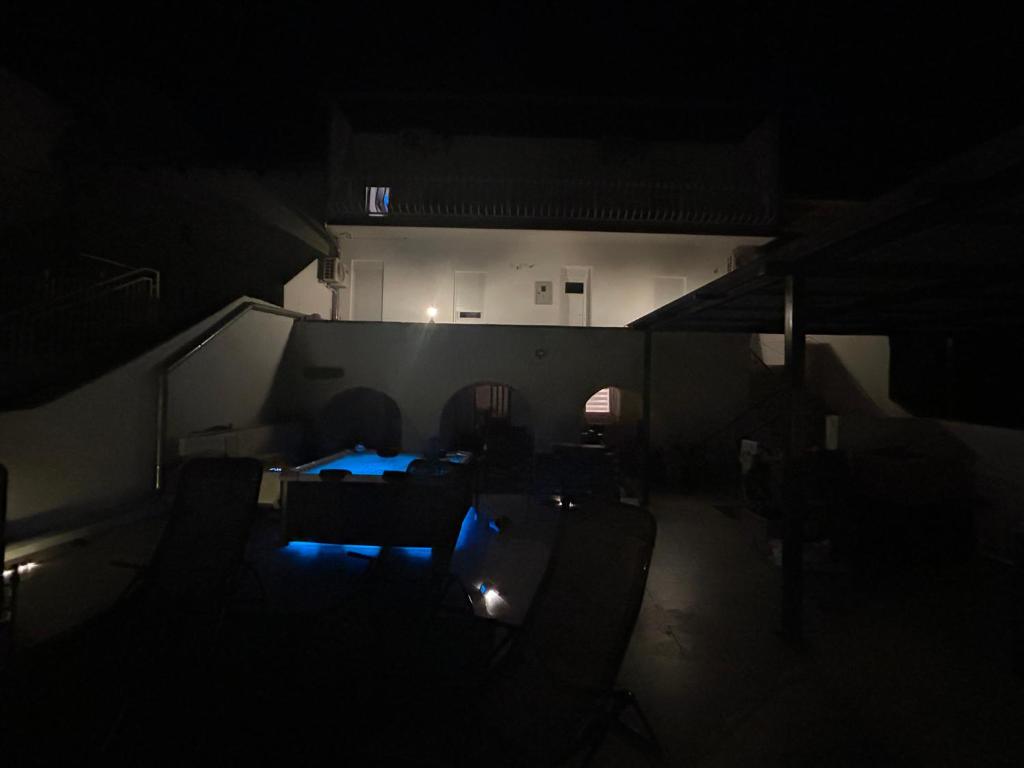 um quarto escuro com uma mesa e cadeiras no escuro em Ferienhaus Dramalj em Dramalj