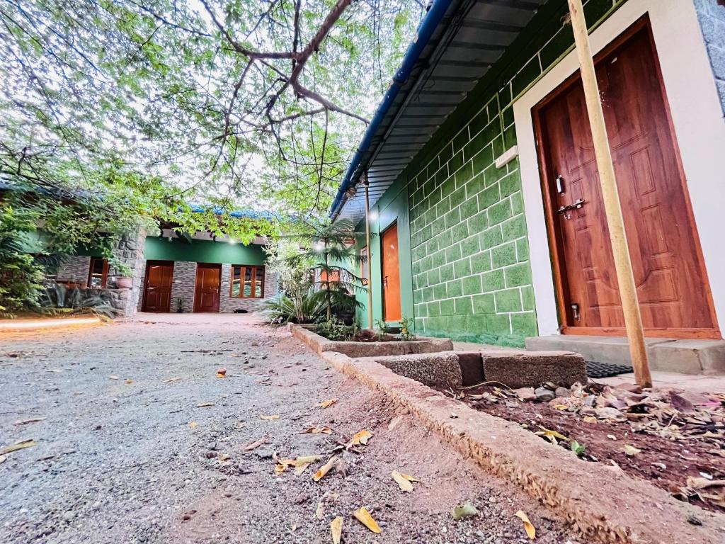 a green brick building with a wooden door at SPM Residency, From Live2Travel Group. in Masinagudi