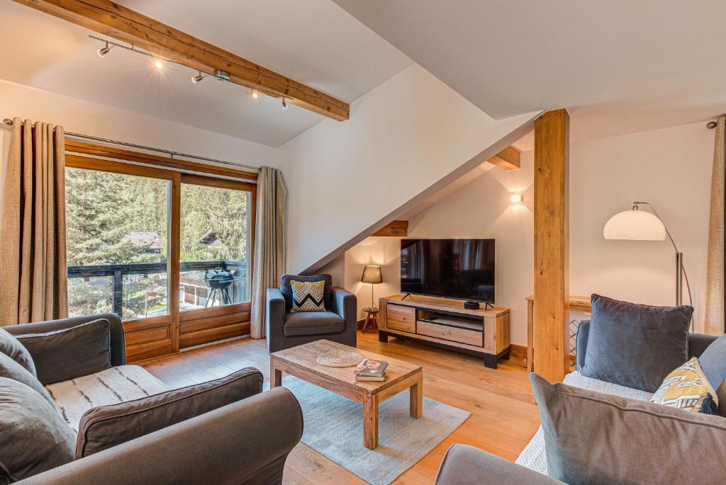 uma sala de estar com dois sofás e uma televisão em Les Melées Apartments - Alpes Travel - Argentiere em Chamonix-Mont-Blanc