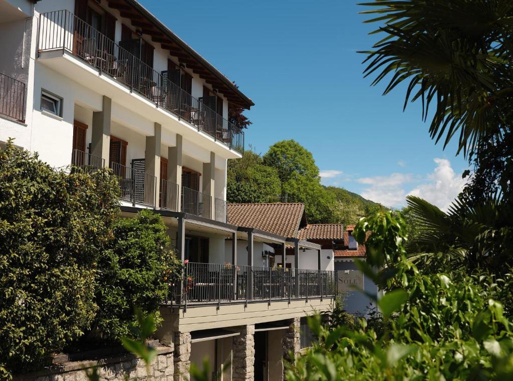 a building with a balcony and a river at Hotel Sole in Cannero Riviera
