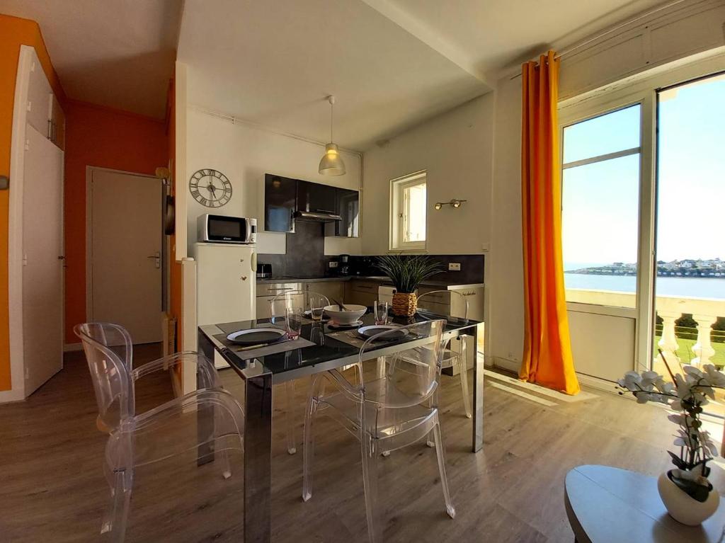 une cuisine et une salle à manger avec une table et des chaises dans l'établissement Royan - VUE MAGIQUE pour cet APPARTEMENT au 1er étage - Résidence du Golf, à Royan