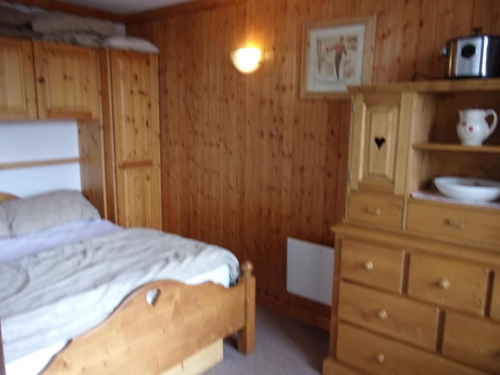 a bedroom with a bed and a wooden dresser at La Villaret in Les Menuires