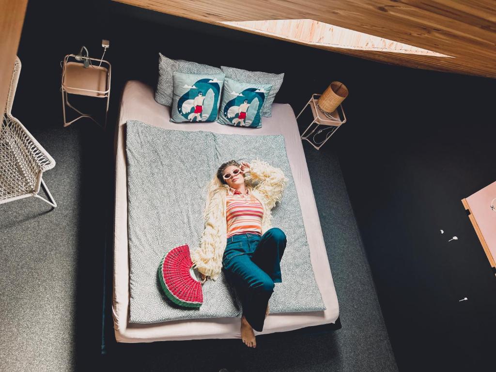 une femme assise sur un lit dans une pièce dans l'établissement 2 STODOŁY Chillout, à Dziwnów