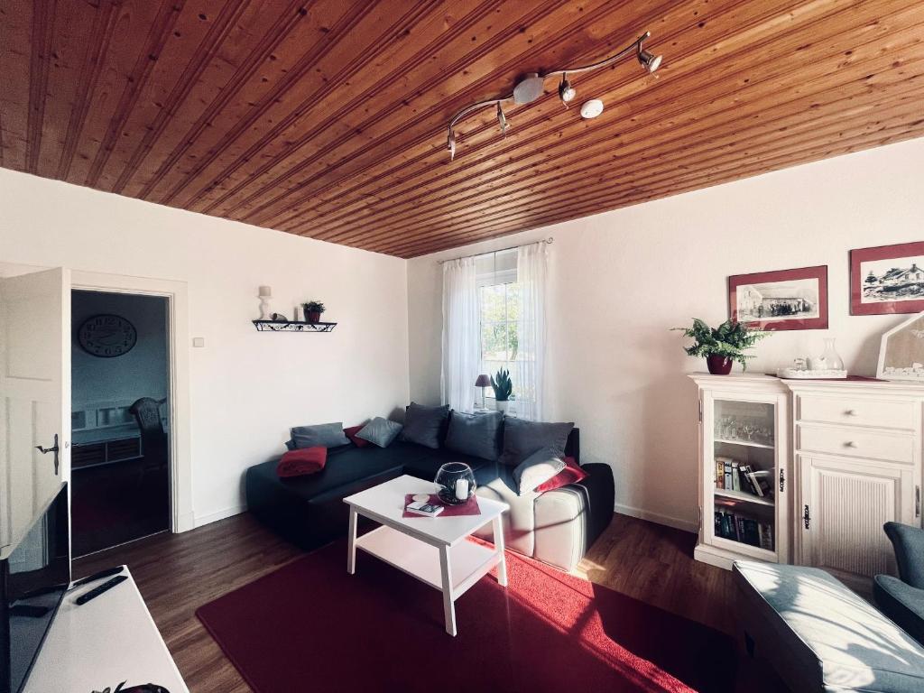 ein Wohnzimmer mit einem Sofa und einem Tisch in der Unterkunft Huuske Lütten Uttied - Das Landleben genießen in Moormerland