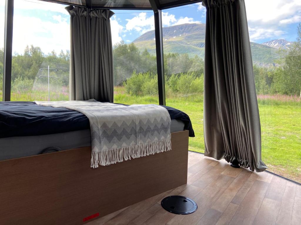een slaapkamer met een bed en een groot raam bij North Experience Basecamp in Melen