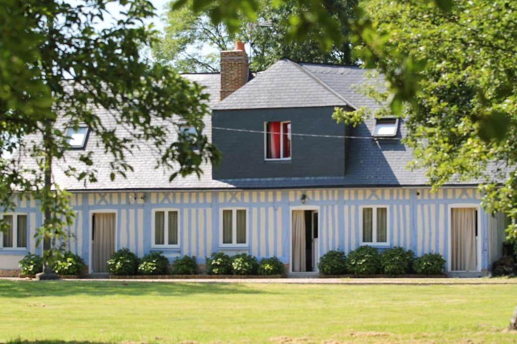 a large blue house with a red window at Blue cottage in Normandie in Ouville-lʼAbbaye