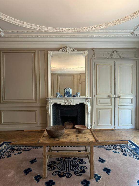 salon ze stołem i kominkiem w obiekcie Maison Saint-Germain-des-Prés w Paryżu