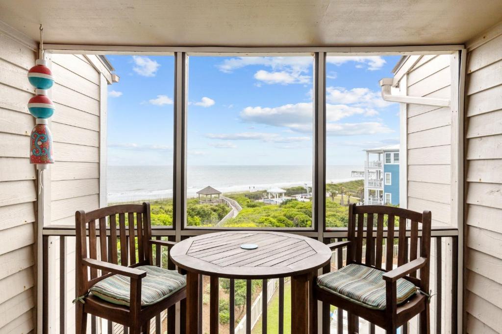 uma varanda com uma mesa e 2 cadeiras, uma mesa e uma vista em Island Time condo em Atlantic Beach