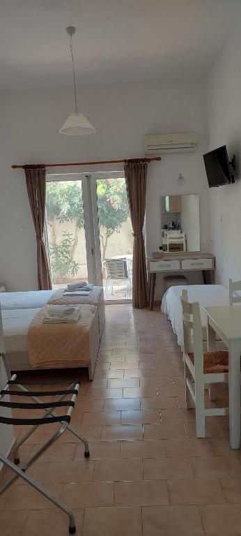 1 Schlafzimmer mit 2 Betten, einem Tisch und einem Schreibtisch in der Unterkunft Sifis Studios in Palaiochóra