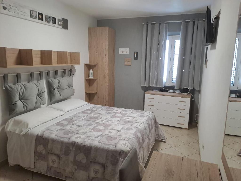 a bedroom with a bed and a dresser and a window at Hotel Mariani in Lido di Camaiore