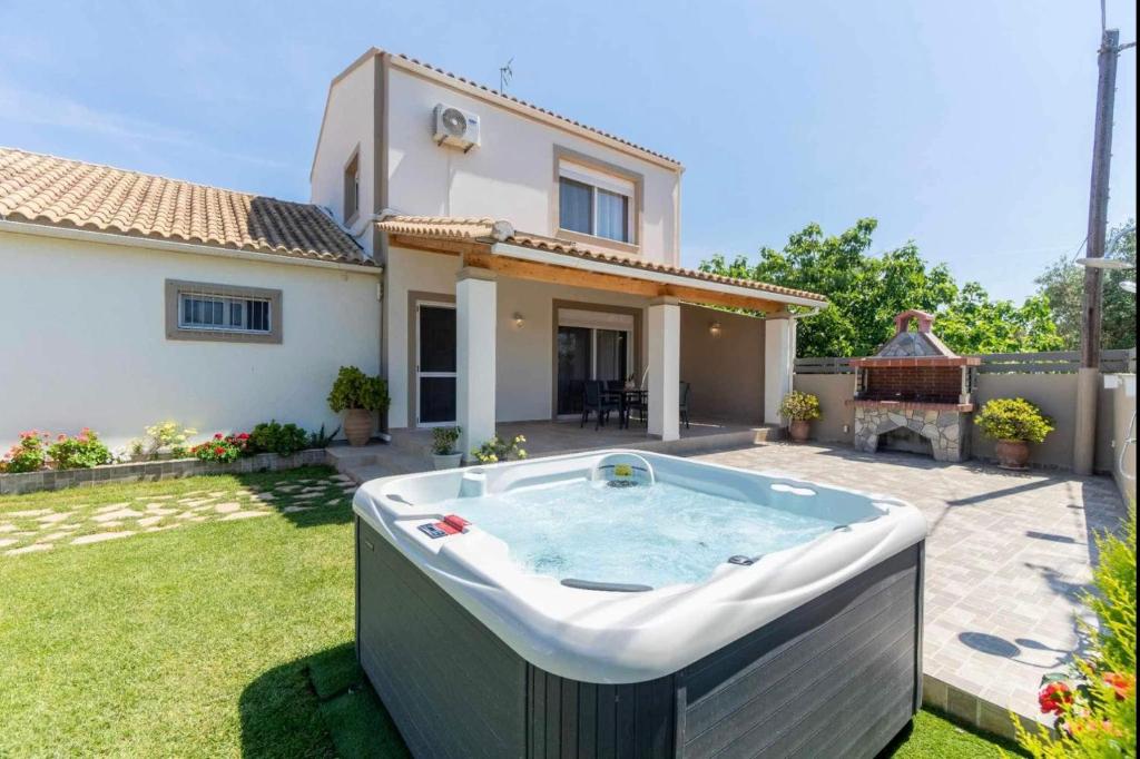 a hot tub in the yard of a house at Villa Tesoro in Agios Georgios