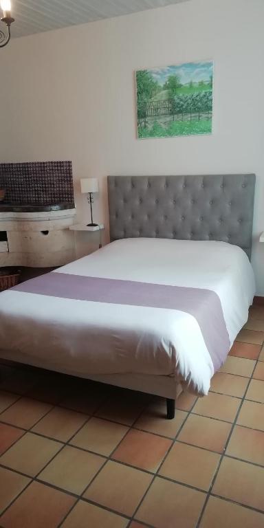 une chambre avec un grand lit blanc dans une pièce dans l'établissement lehavredejulie, à Saint-Sigismond