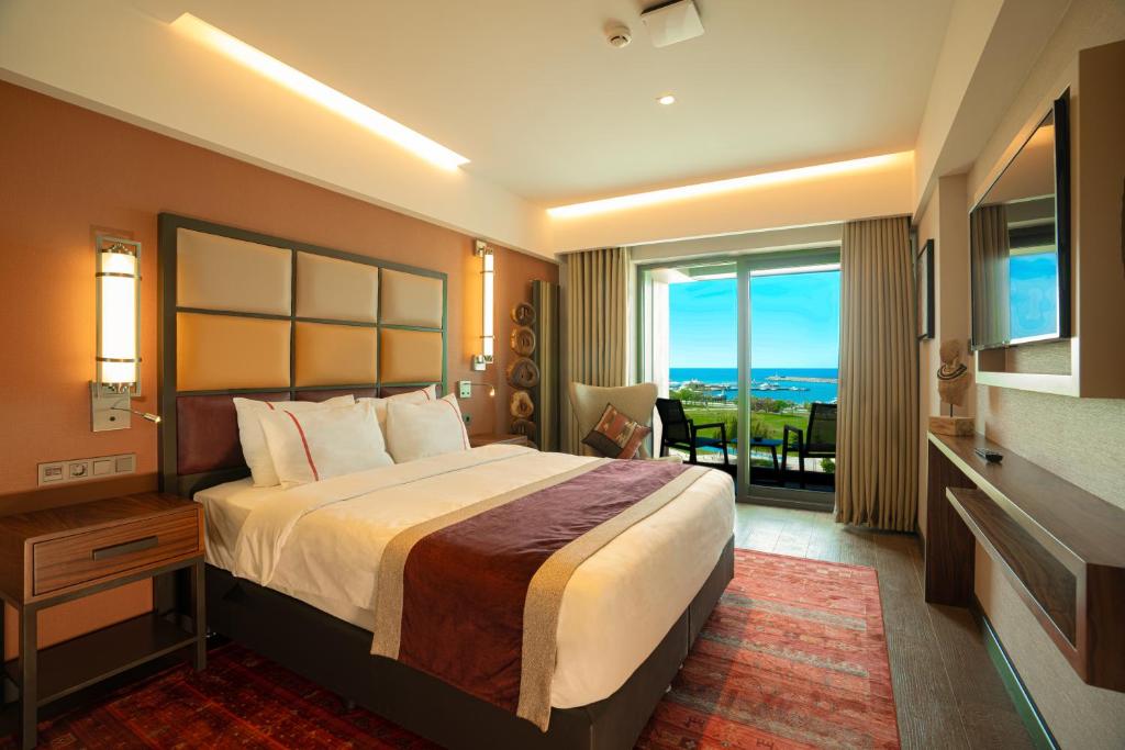 a hotel room with a large bed and a balcony at Sile Gonen Hotel in Şile
