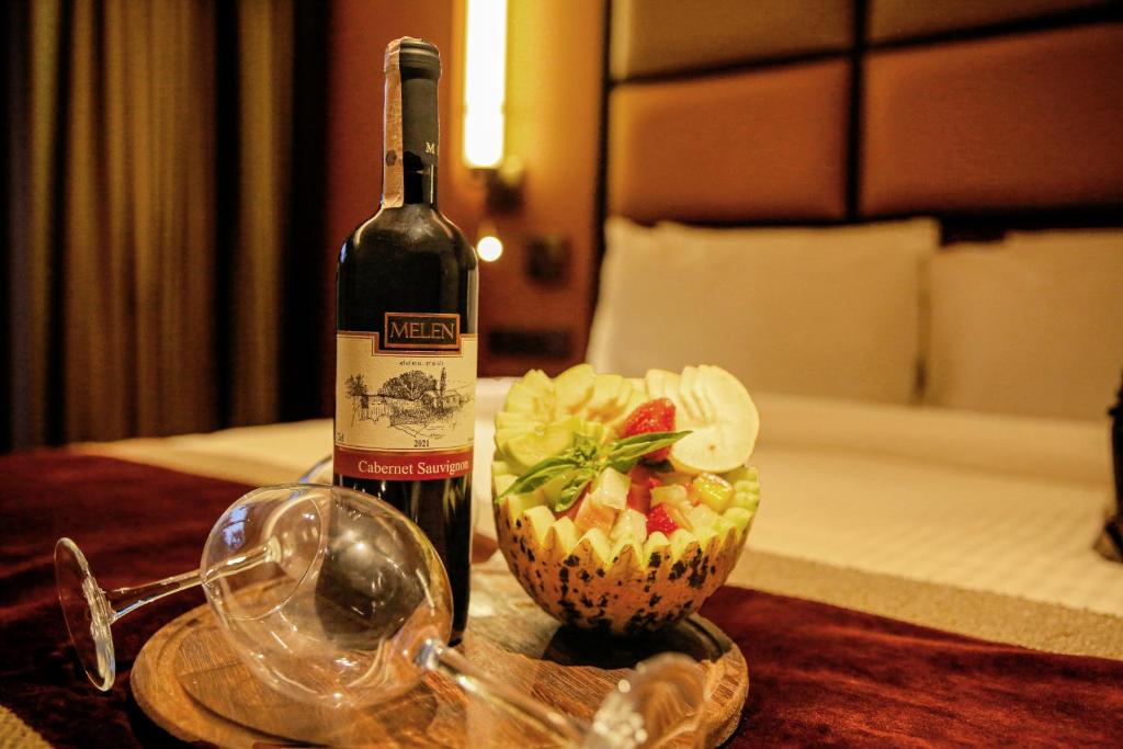 a bottle of wine and a bowl of fruit on a table at Sile Gonen Hotel in Şile