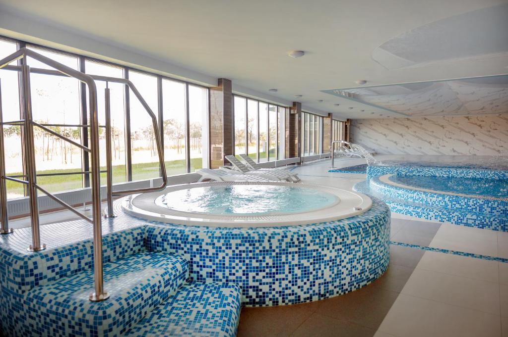 two pools in a building with blue and white tiles at Porta Mare Resort & SPA Apartament Dziwnów in Dziwnów