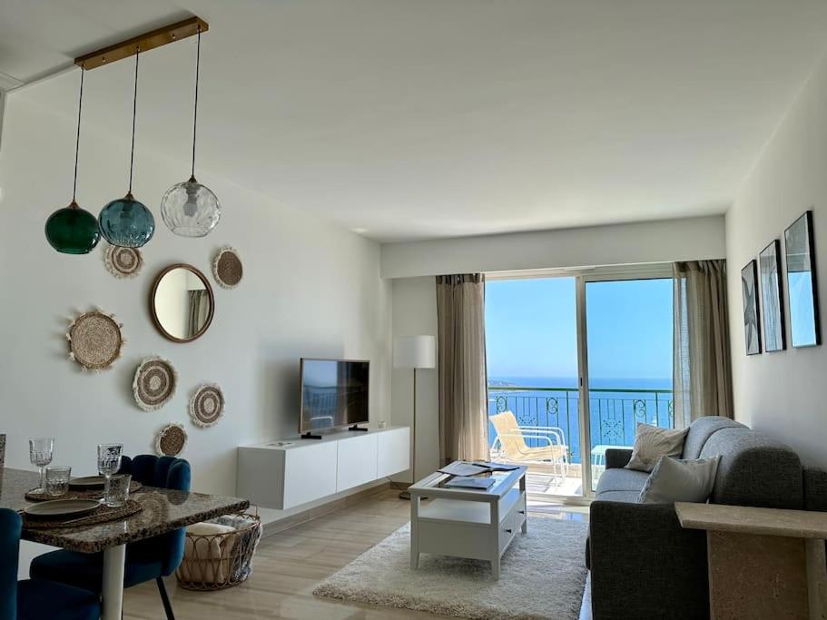 un salon avec un canapé, une table et une télévision dans l'établissement Splendide vue mer, proche centre Beausoleil, à Beausoleil