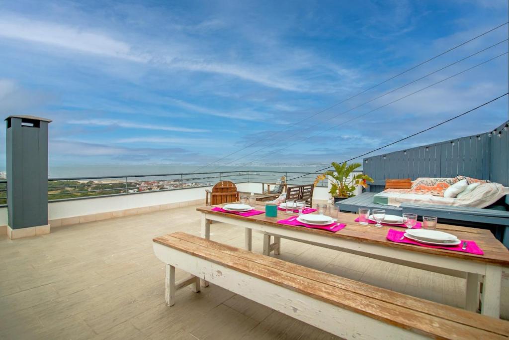 una mesa en un balcón con vistas en Rooftop Océan à 180º - Trafaria en Trafaria