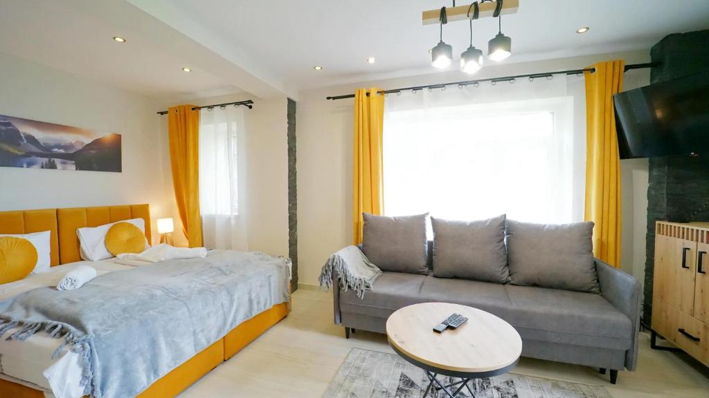 - une chambre avec un lit et un canapé dans l'établissement Apartamenty EverySky - Karkonoska 30, à Karpacz
