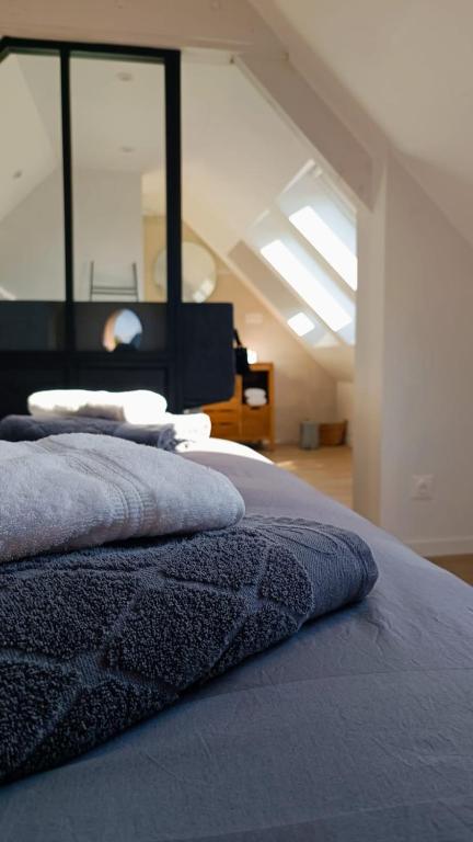 un lit avec des oreillers dessus dans une chambre dans l'établissement Mont Gîte Des Herbus Puccinellie avec Jacuzzi 2 personnes entre Granville et Mont Saint Michel, à Vains