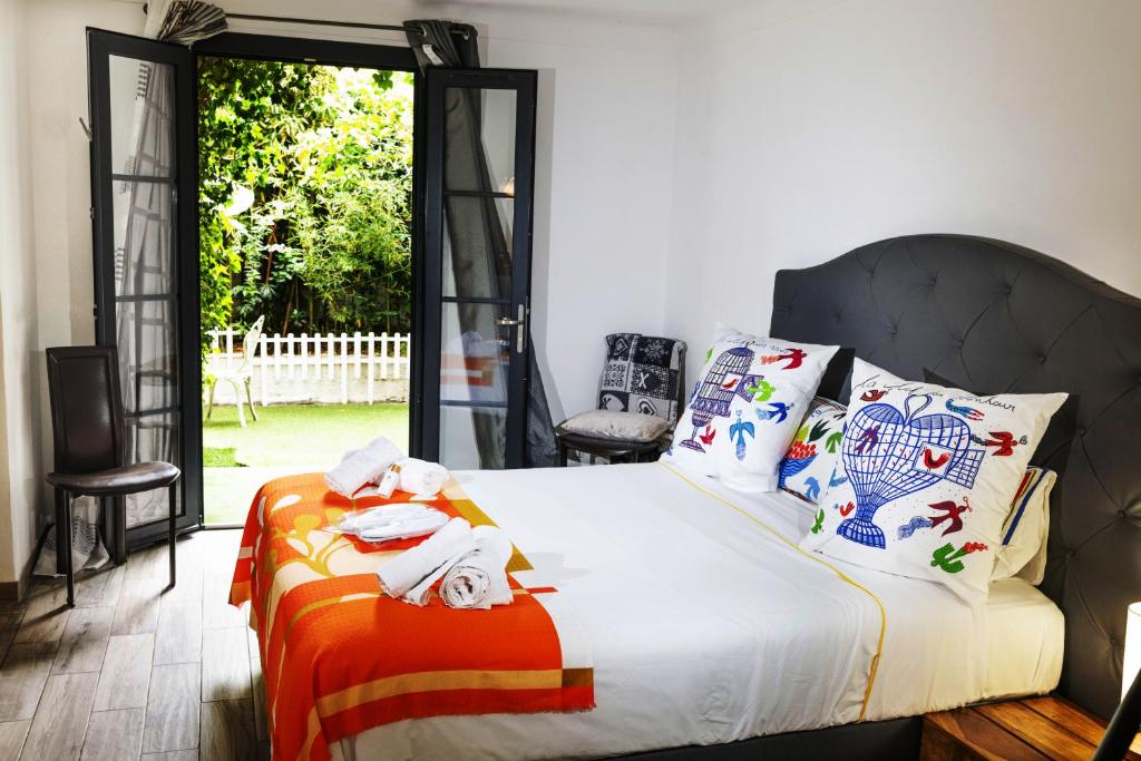 - une chambre avec un lit doté d'oreillers et d'une fenêtre dans l'établissement la Romana Luxe et sérénité au cœur de Saint-Tropez Suites spacieuses avec jardin enchanteur, à Saint-Tropez